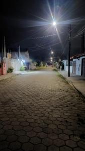 an empty street at night with a street light at ótima casa em Itanhaém in Itanhaém