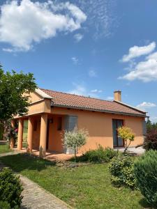 a house in a yard with a sky at Colonia Natura Apartmanpark in Sitke