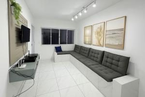 a living room with a couch and a television at Sobrado Maré Mansa in Peruíbe