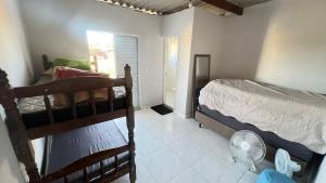 a bedroom with two bunk beds and a fan at Sobrado Maré Mansa in Peruíbe