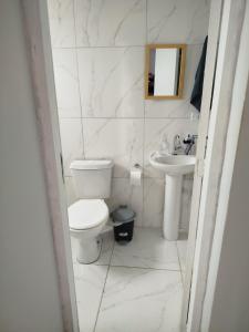 a white bathroom with a toilet and a sink at Sobrado Maré Mansa in Peruíbe +9 photos