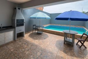 a kitchen with a pool and a table with an umbrella at Sobrado Maré Mansa in Peruíbe