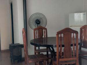 a dining room table with chairs and a fan at La casa de Los Patitos in Arroyo de Los Patos
