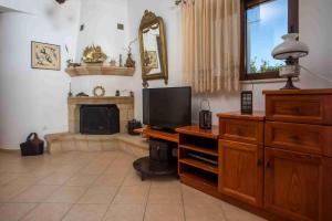 a living room with a television and a fireplace at Christine Beachside Villa Pefkos in Pefki