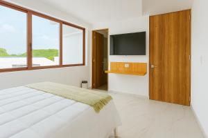 a bedroom with a bed and a tv on a wall at Riviera Hotel Boutique in Cali