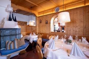 a restaurant with white tables and chairs and a window at Seefeldstub'n in Kirchberg in Tirol