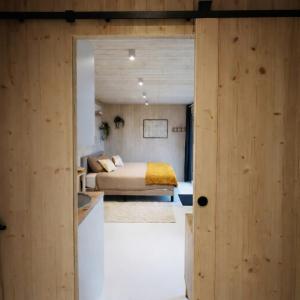 a bedroom with a bed in a room with wooden walls at Tiny House Eole - Proche Issoudun, Safran, Rwe - Zone artisanale in Saint-Georges-sur-Arnon
