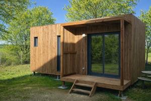 a wooden tiny house with a table in a field at Tiny House Eole - Proche Issoudun, Safran, Rwe - Zone artisanale in Saint-Georges-sur-Arnon