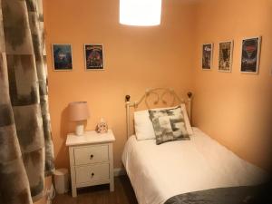 a small bedroom with a white bed and a nightstand at Bay Lodge Guest House in Eastbourne