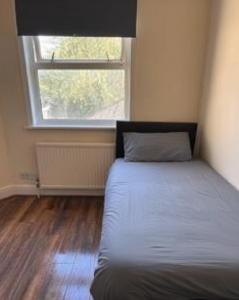 a bed in a room with a large window at Atherley House - Winter Sale! Spacious Self Catered Rooms in Southampton