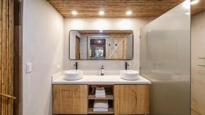 a bathroom with two sinks and a mirror at Norte Nosara - Steps to Playa Guiones in Nosara