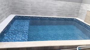 a swimming pool in a bathroom with a tile wall at ótima casa em Itanhaém in Itanhaém