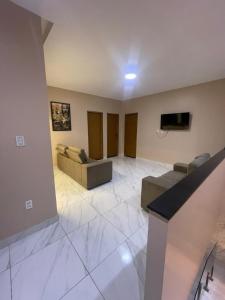 a living room with two couches and a flat screen tv at Casa veraneio2 in Camacari