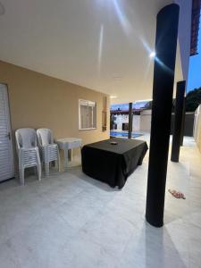 a bedroom with a bed and a table and chairs at Casa veraneio2 in Camacari