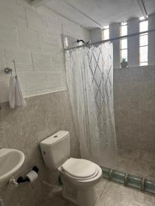 a white bathroom with a toilet and a sink at Alojamiento campestre in Cali +7 photos