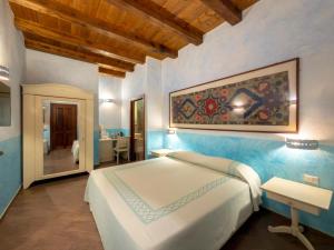 a bedroom with a large white bed and a table at SU PASSU Country House in Fertilia