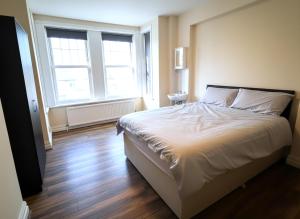 a bedroom with a large bed and a large window at Atherley House - Winter Sale! Spacious Self Catered Rooms in Southampton