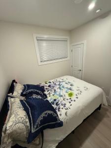 a bedroom with a bed with a blanket and a window at 2 Bedrooms Private EntRance wifi Free Parking in Prince George