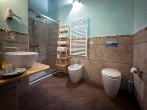 a bathroom with a sink and a toilet and a shower at SU PASSU Country House in Fertilia +39 photos