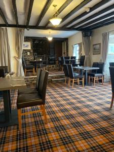 a waiting room with chairs and tables in a building at The Dog & Partridge Country Inn in Ashbourne