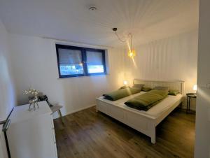 a bedroom with a bed with green pillows and a window at Wohnen am Wald mit Pool & Sauna in Unterkirnach