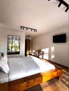 a bedroom with a large bed and a flat screen tv at Woodland Retreat in Ampoiţa
