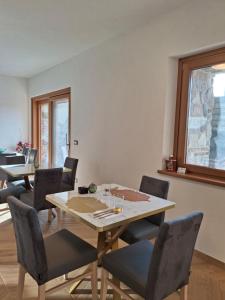 a dining room with tables and chairs and a window at Vie D'Alt Wine and Rooms in Prepotto
