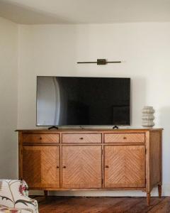 a flat screen tv sitting on top of a wooden dresser at Luxurious Town Centre Apartments in Cirencester