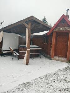 a building with a table and a screen in front of it at Całoroczne Domki "Stokrotka" in Solina