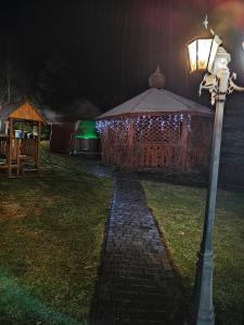 a street light next to a gazebo with christmas lights at Całoroczne Domki "Stokrotka" in Solina