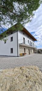 a large white building with a balcony on top of it at Vie D'Alt Wine and Rooms in Prepotto