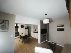 a living room with a kitchen and a dining room at maison cosy proche du port et plage in Grand-Fort-Philippe