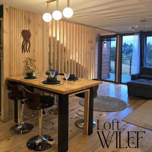a living room with a wooden table and chairs at Loft Wilef in Tentén