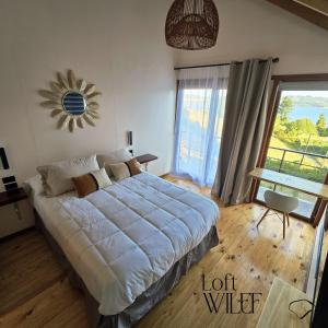 a bedroom with a large bed and a large window at Loft Wilef in Tentén