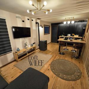 a living room with a long table and a television at Loft Wilef in Tentén