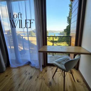 a table and a chair in front of a window at Loft Wilef in Tentén