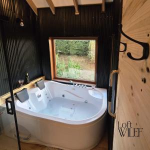 a large white tub in a room with a window at Loft Wilef in Tentén +11 photos