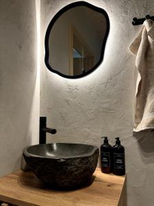 a bathroom with a stone sink and a mirror at Chalet Plechovka in Frýdštejn +16 photos