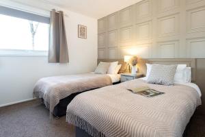 two beds sitting next to each other in a bedroom at Swanmere lodge, Lakeside view Pinelake Carnforth in Carnforth +35 photos