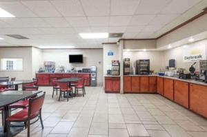 a restaurant with tables and chairs and a cafeteria at Days Inn by Wyndham San Antonio Splashtown/ATT Center in San Antonio