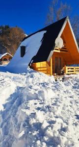 a cabin in the snow with a pile of snow at Vikendica i odmaraliste JuliE, Sarajevo-Jahorina in Tvrdimići
