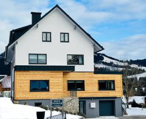 a house with white and wood at Haus Stadler - Self Check-in in Tauplitz