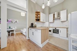 a kitchen with white cabinets and a table in it at EUPHORAS - Central & Stylish Apartment - Parking in Bad Harzburg