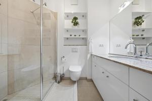 a white bathroom with a toilet and a shower at EUPHORAS - Central & Stylish Apartment - Parking in Bad Harzburg +11 photos
