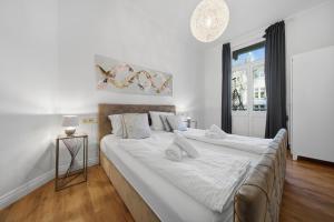 a large white bed in a room with a window at EUPHORAS - Central & Stylish Apartment - Parking in Bad Harzburg