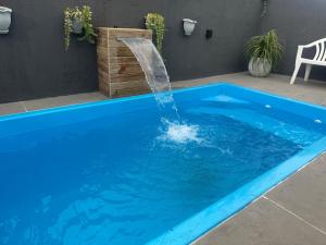 a swimming pool with a water fountain at Excelente casa com piscina próx ao Mar in Capão da Canoa