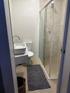 a bathroom with a toilet and a sink and a shower at Excelente casa com piscina próx ao Mar in Capão da Canoa +2 photos