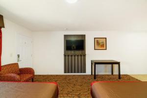 a room with a tv and a chair and a table at HIgh Five Inn Killeen-Forthood in Killeen