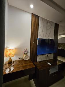 a desk with a lamp and a television in a room at Elevenstay in Ghaziabad