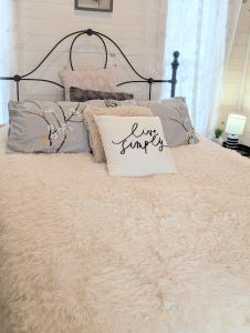 a bed with a white comforter and pillows on it at Field and Fern Cottages in Tatamagouche